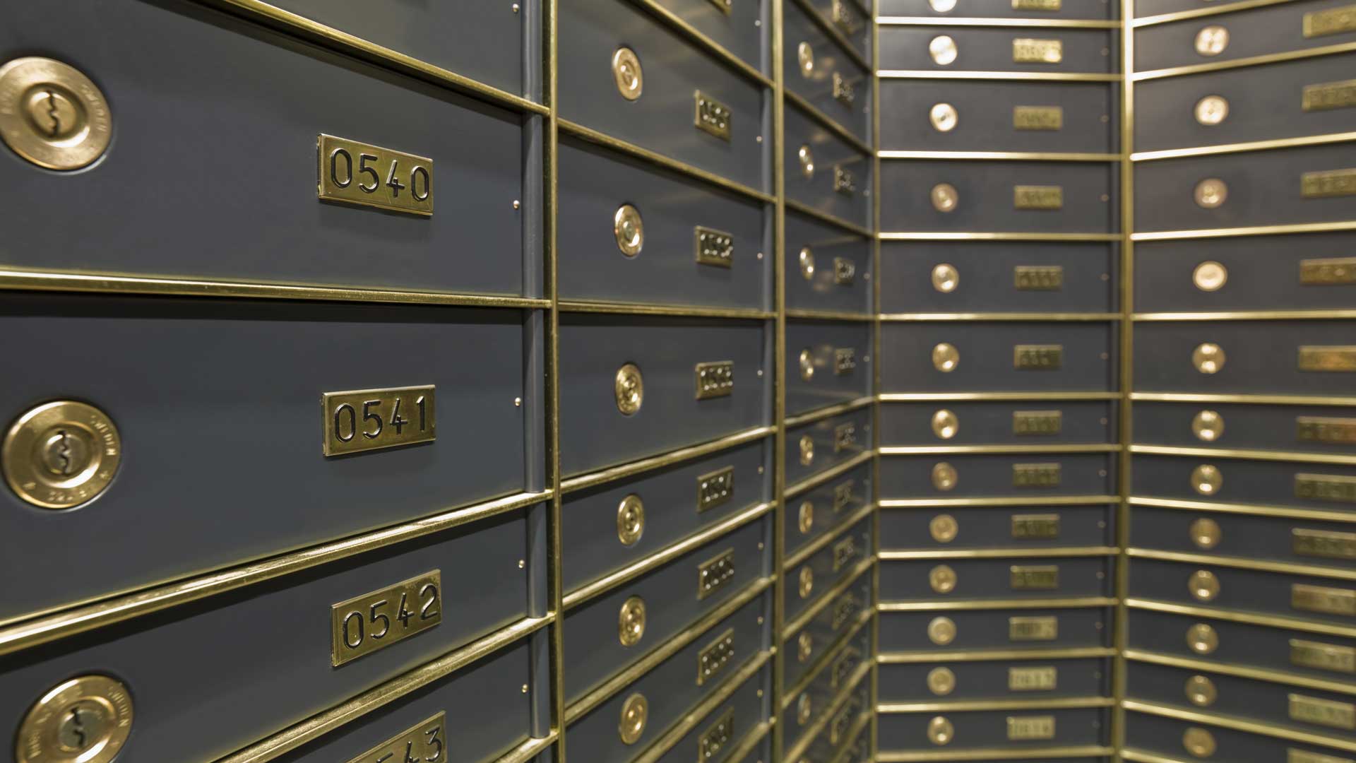 Wall of gold-framed numbered safe deposit boxes