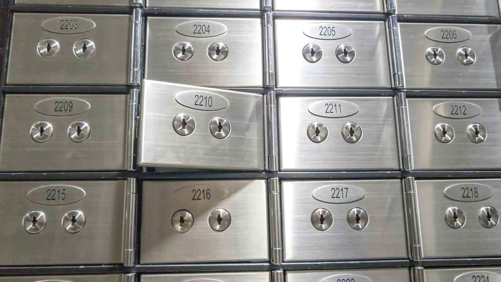 Close-up of stainless steel safe deposit boxes with dual key locks